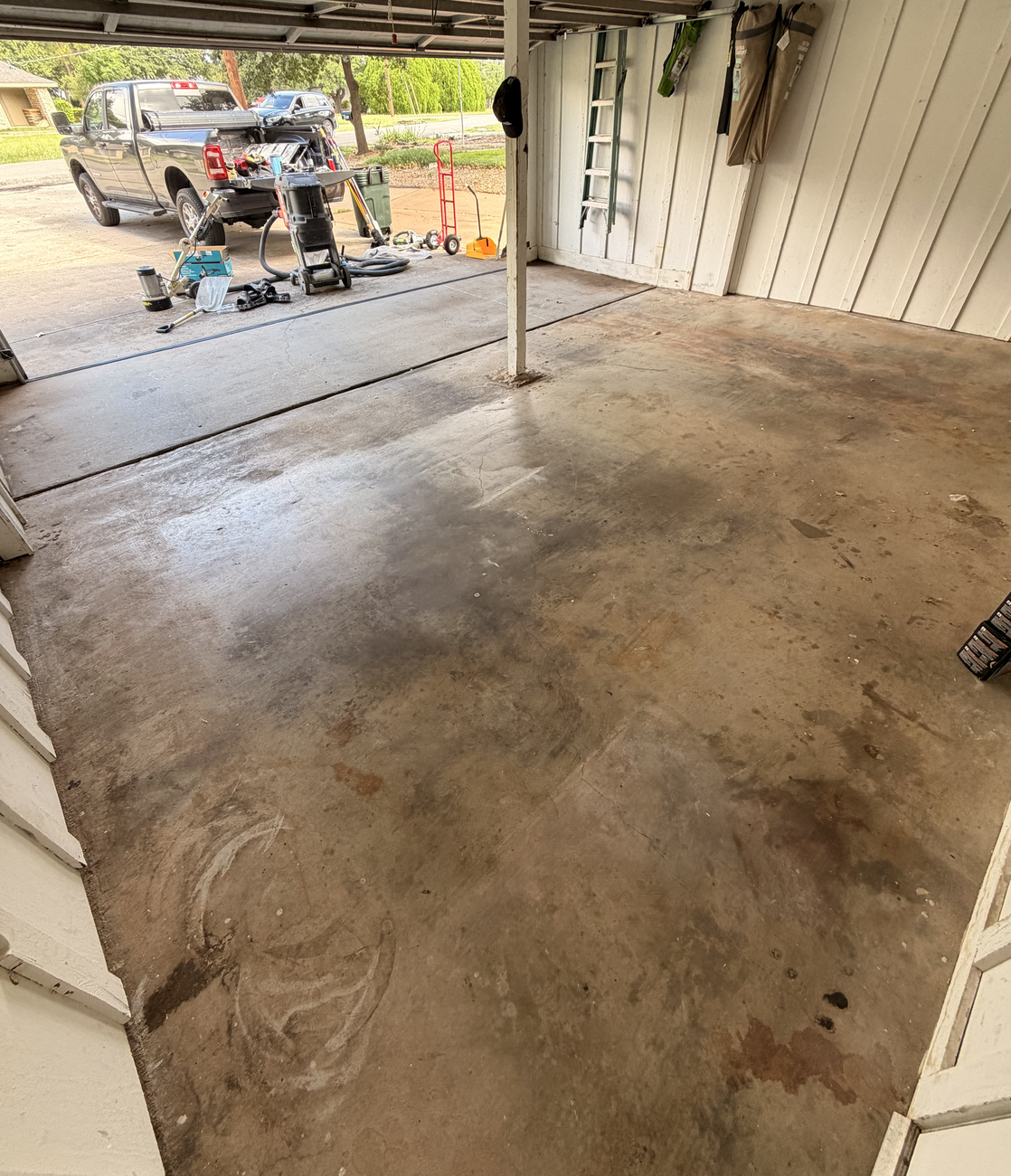 Stained bare concrete garage floor in Granbury before a Happy Slab coating