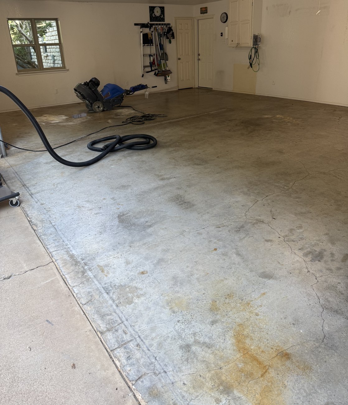 Bare stained concrete garage floor in DeCordova before coating