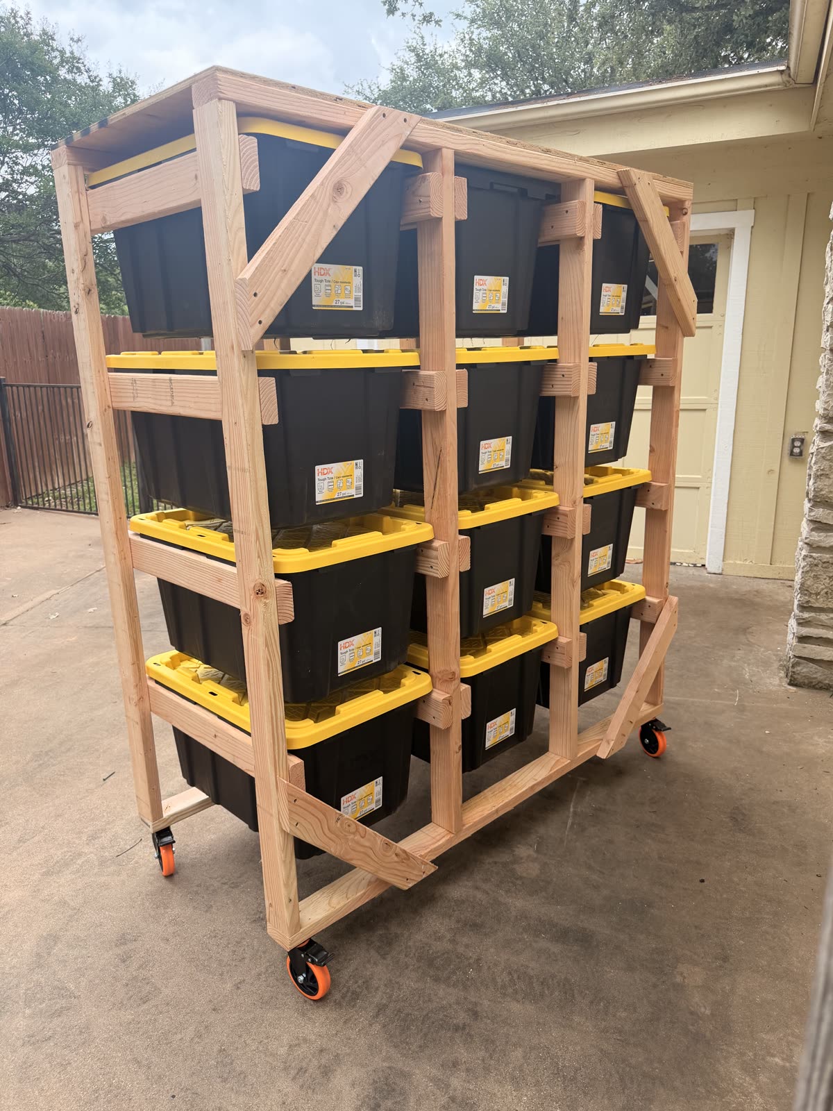 A cross-braced 12-tote rolling rack loaded with new HDX totes on a driveway